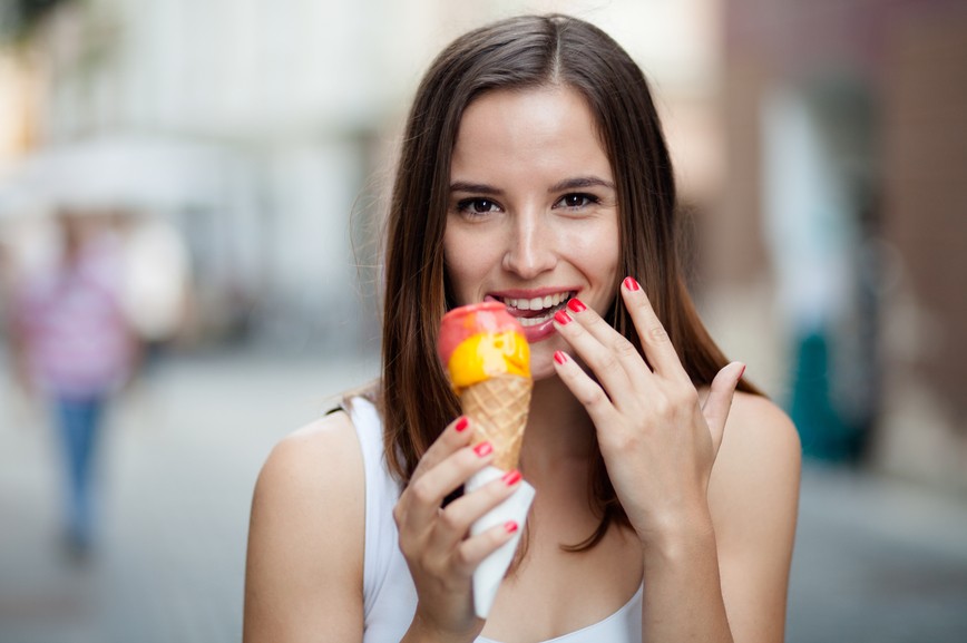 Young woman eating ice cream on the street
