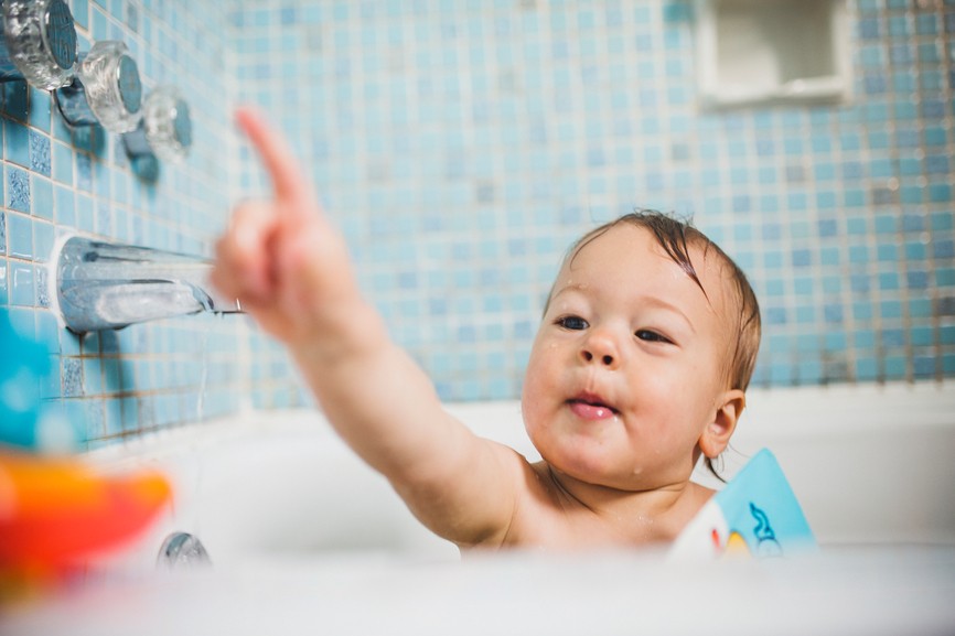 Cute baby boy having fun in bath tub