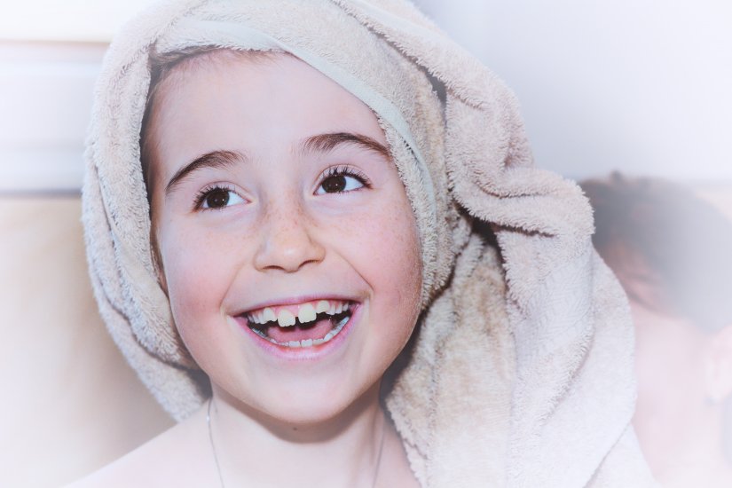 Emolienty w pielęgnacji AZS - dziecko w ręczniku
